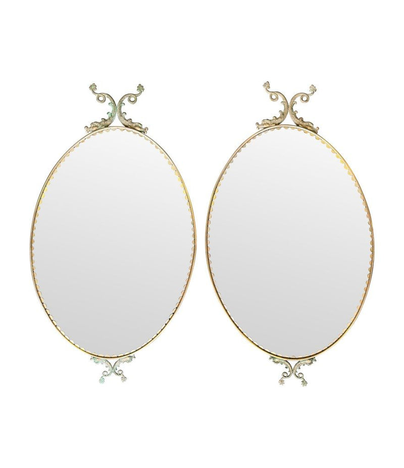 A pair of Italian 1940s oval mirrors with dolphin detailing around the brass frame