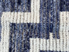 A handmade Morrocan Beni Ourain Berber rug with blue and white stepped design.