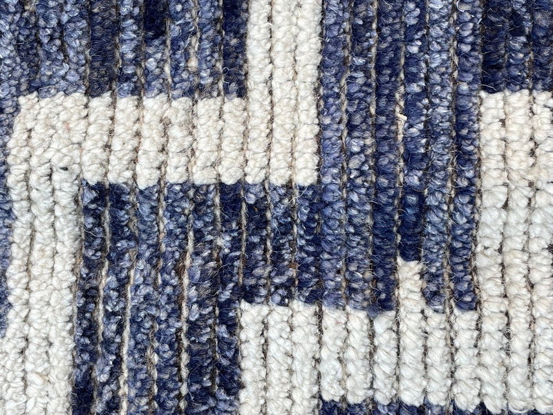 A handmade Morrocan Beni Ourain Berber rug with blue and white stepped design.