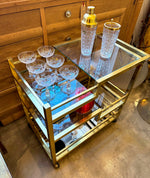 A 1970s Romeo Rega Italian bar trolley with multiple smoked glass shelves