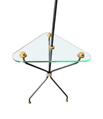 A 1950s French black lacquer and brass tripod floor lamp with glass centre table