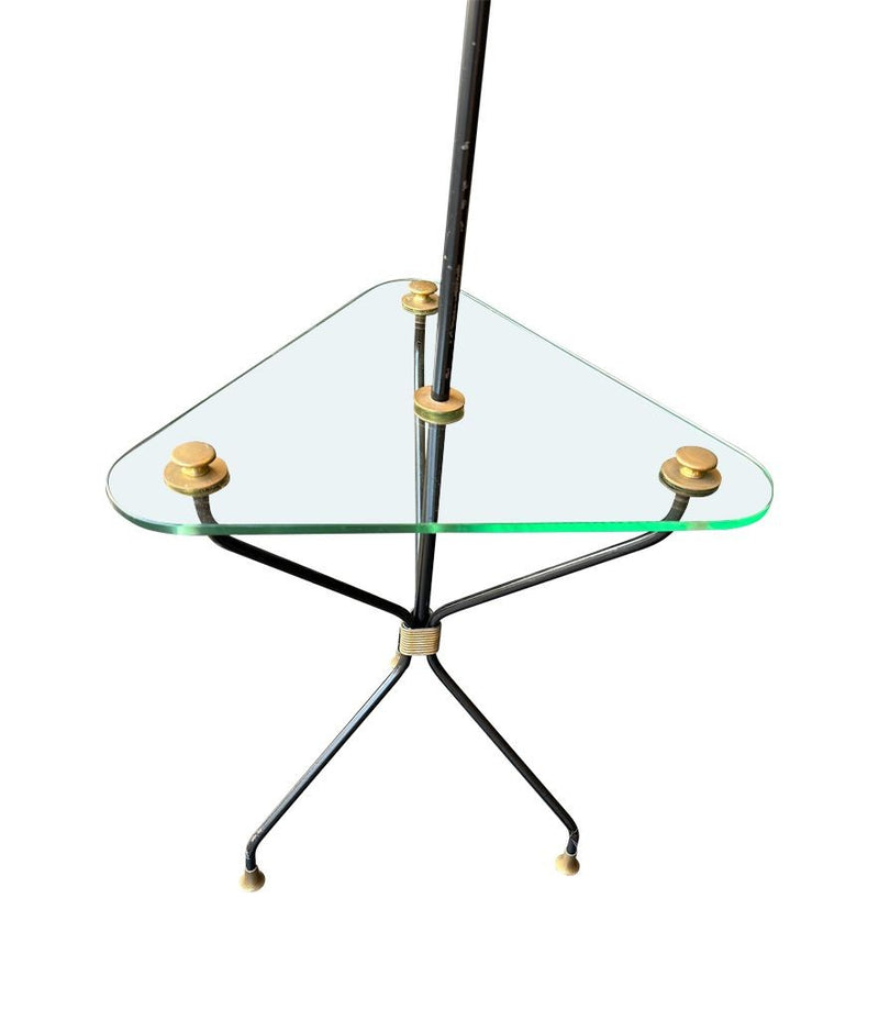 A 1950s French black lacquer and brass tripod floor lamp with glass centre table