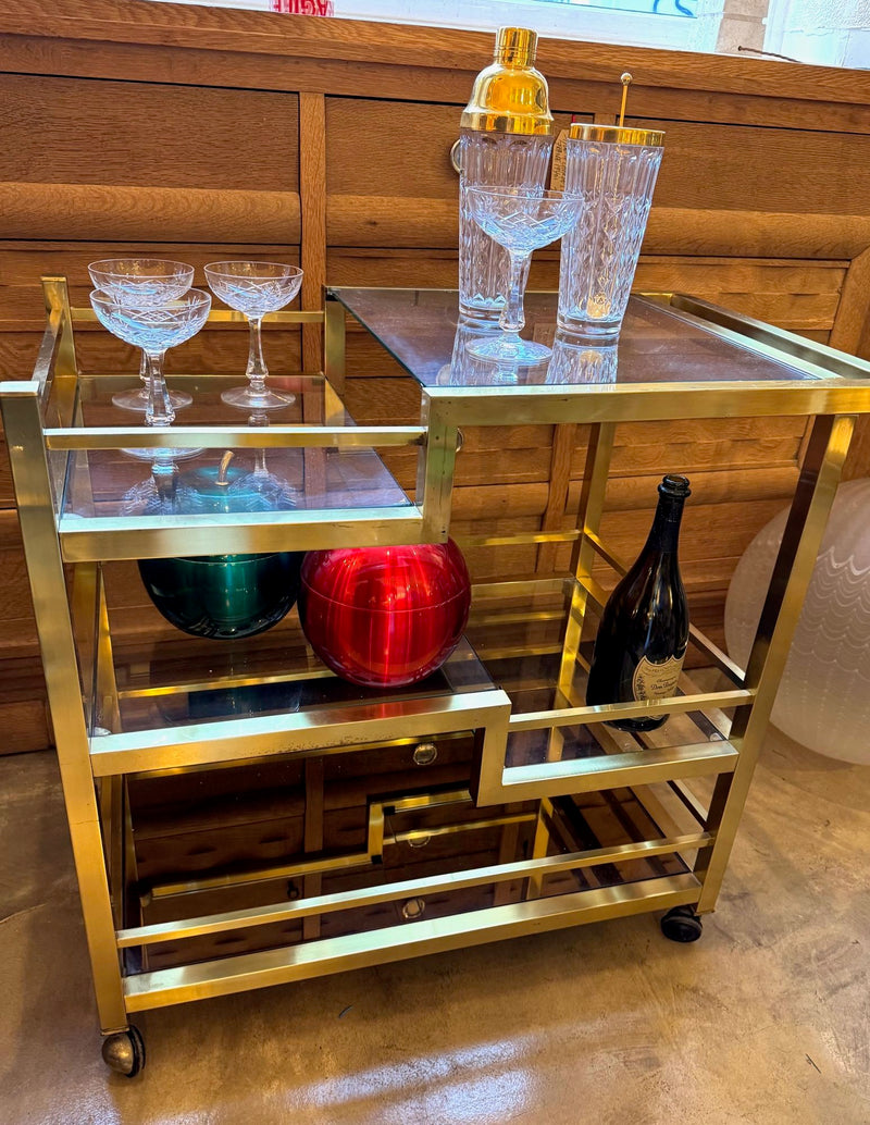 A 1970s Romeo Rega Italian bar trolley with multiple smoked glass shelves