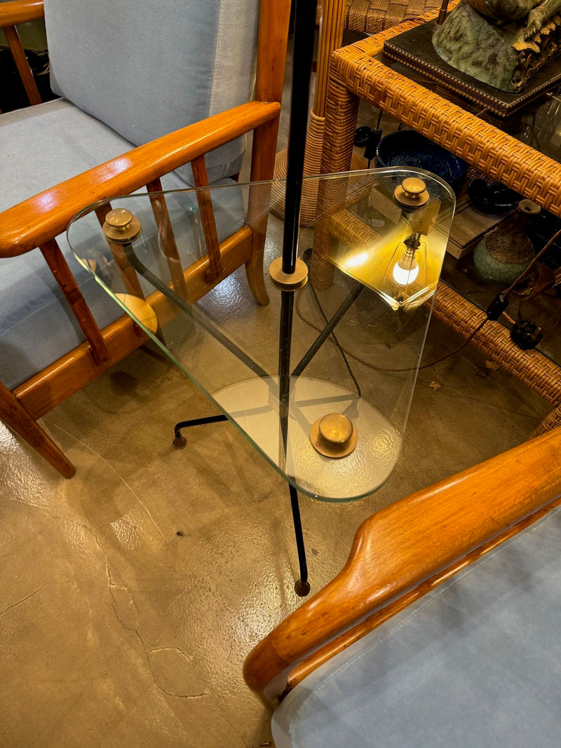 A 1950s French black lacquer and brass tripod floor lamp with glass centre table