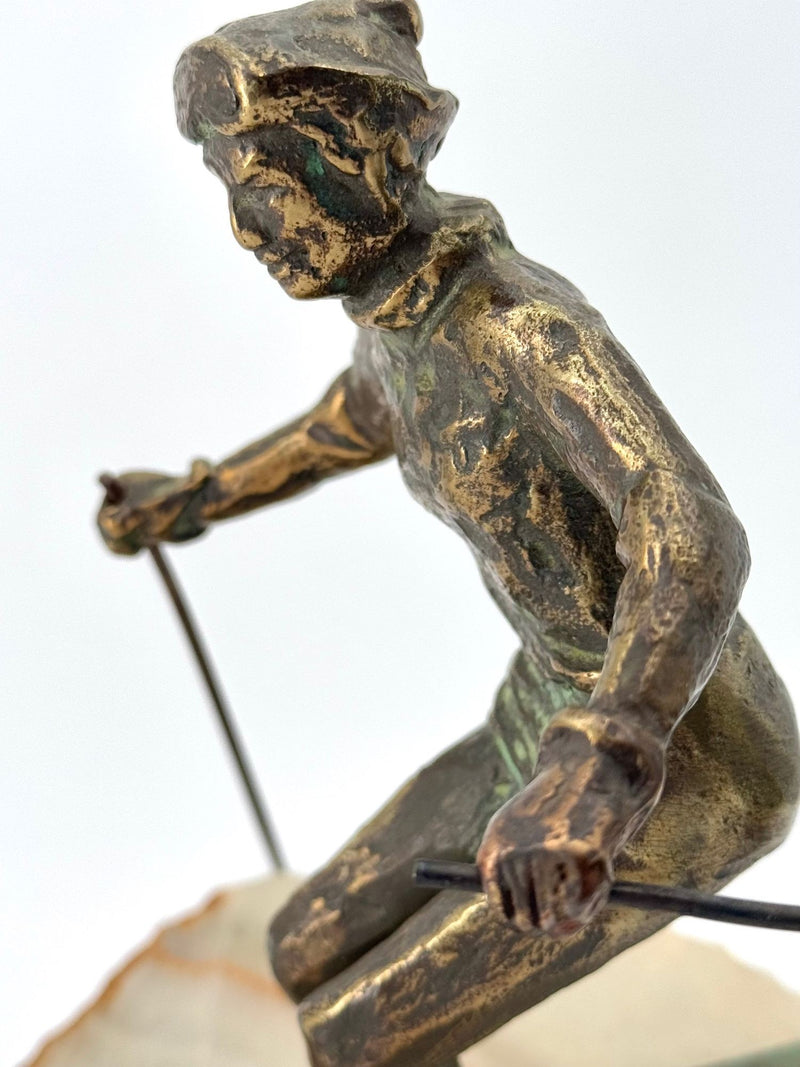 A large pair of bronze cast skiers by Curtis Jere mounted on onyx slabs