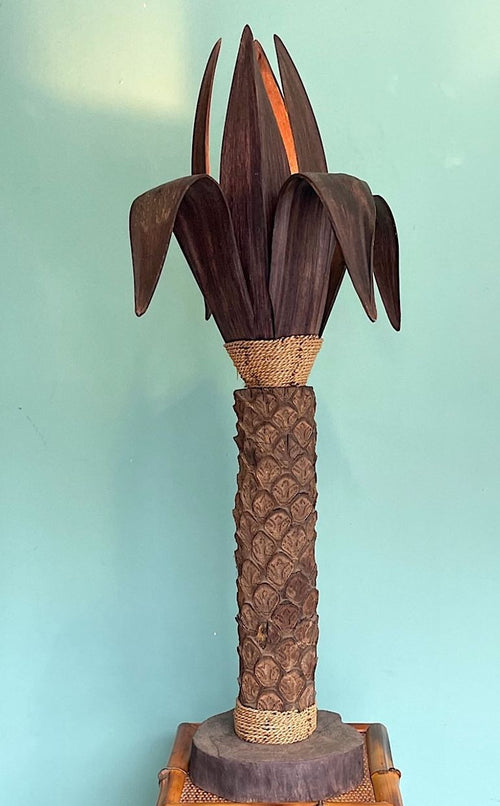 An unusual palm tree floor lamp with real palm trunk wooden base and wooden shaped leaves