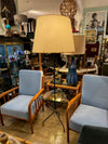 A 1950s French black lacquer and brass tripod floor lamp with glass centre table