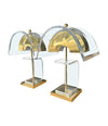 A large unusual pair of 1980s lucite and brass lamps with curved lucite shade and base