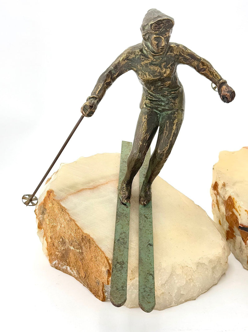 A large pair of bronze cast skiers by Curtis Jere mounted on onyx slabs