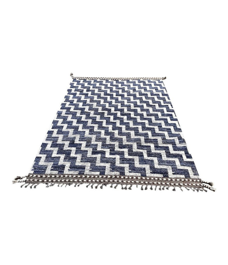 A handmade Morrocan Beni Ourain Berber rug with blue and white stepped design.