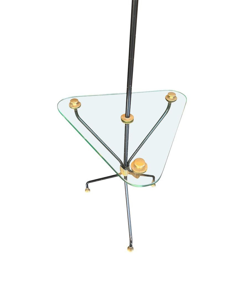 A 1950s French black lacquer and brass tripod floor lamp with glass centre table